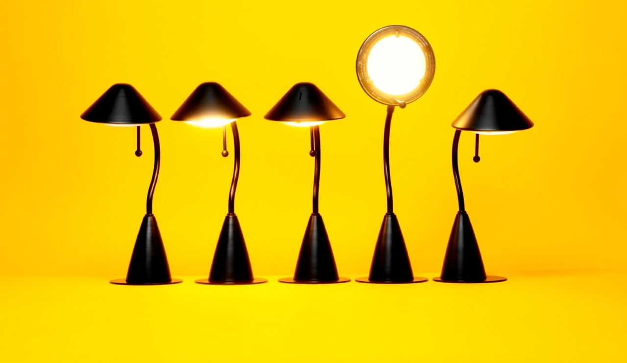 5 desk lamps with the 4th one facing forward on a yellow background