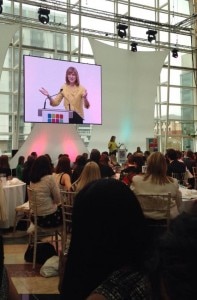 people at tables watching a presenter on a screen