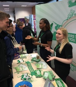 People interacting at the Enterprise table at a job fair