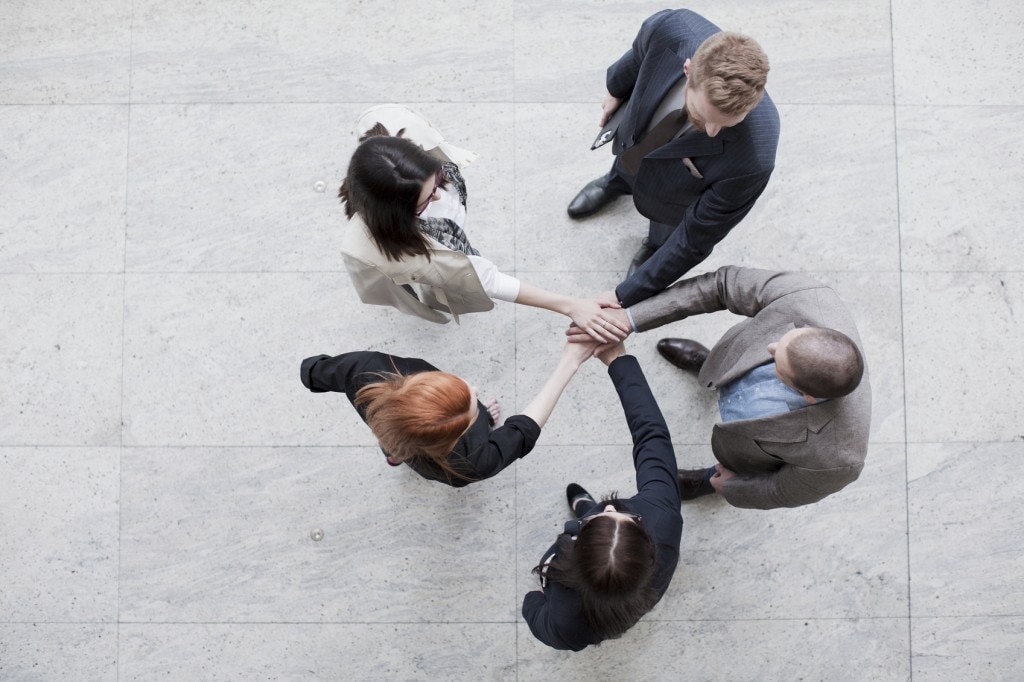 Aerial view of team with hands in the middle